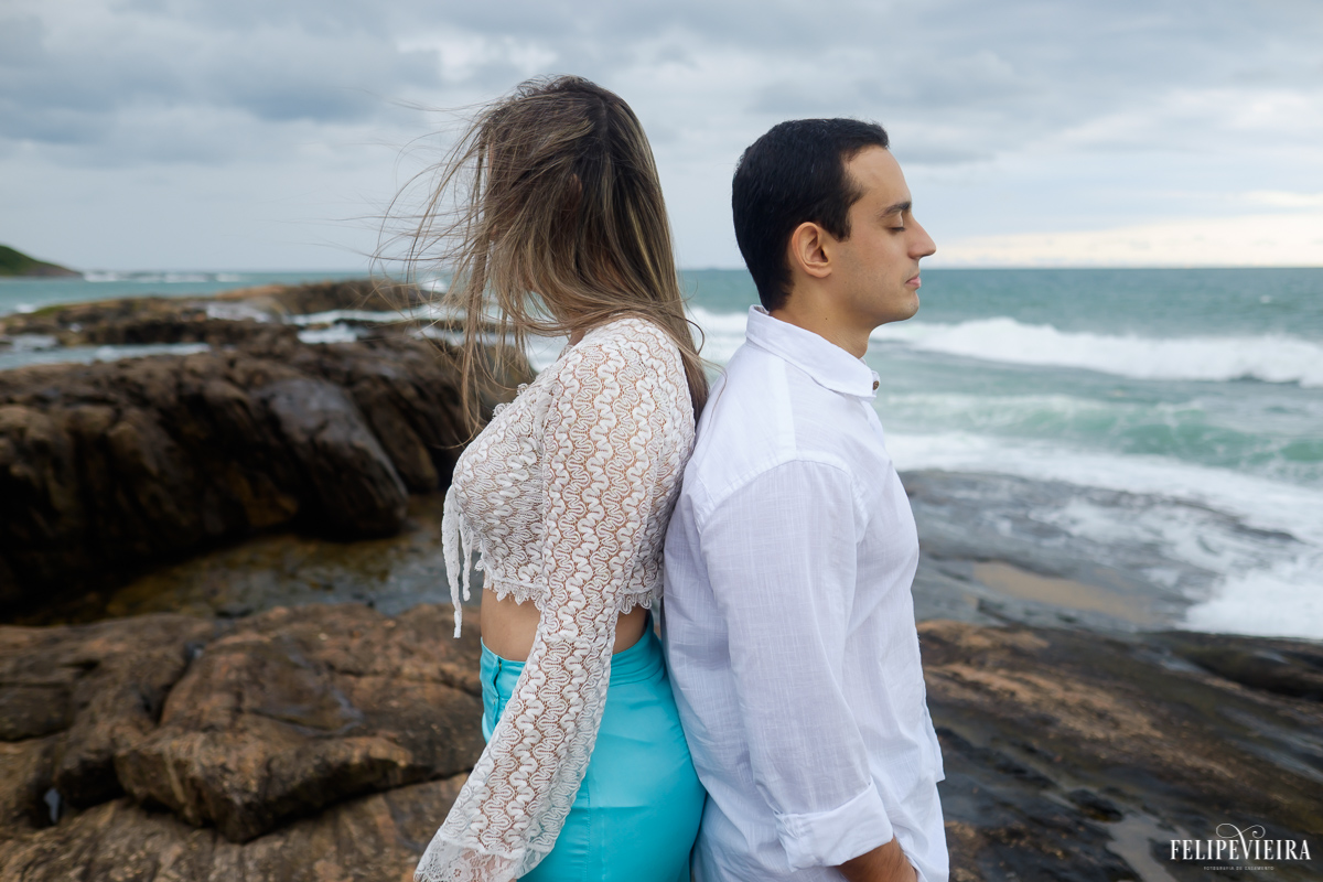 casal de costas um para o outro na frente do mar Guarapari, foto feita por Felipe Vieira fotógrafo de casamentos.