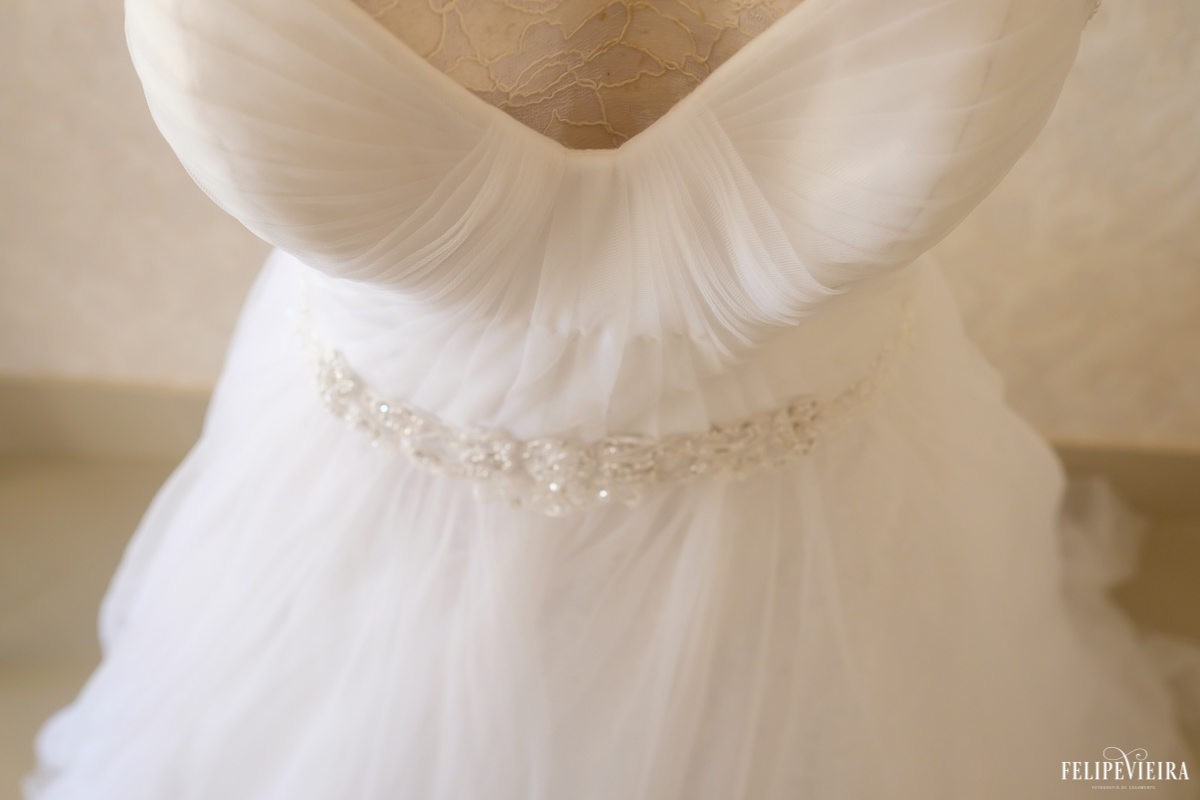 detalhe do vestido da noiva no dia do casamento da Erica foto do fotógrafo felipe vieira fotografia de casamento em Guarapari