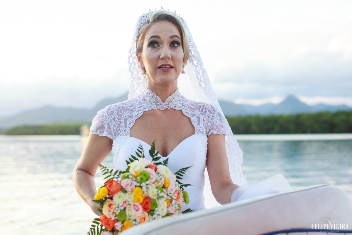 noiva ansiosa chegando na cerimonia de lancha em casamento à beira do mar foto do fotógrafo felipe vieira fotografia de casamento