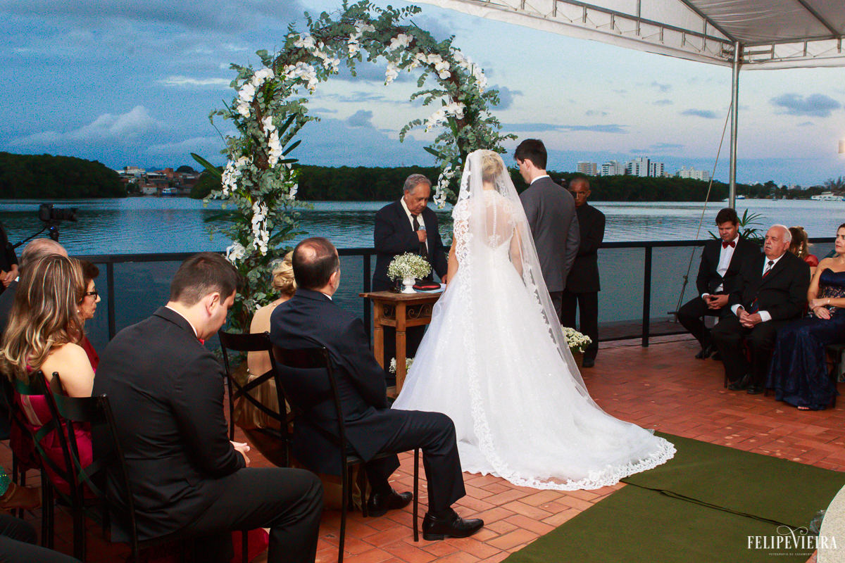 noivos de frente para o altar montado na beira do mar em guarapari foto do fotógrafo felipe vieira fotografia de casamento