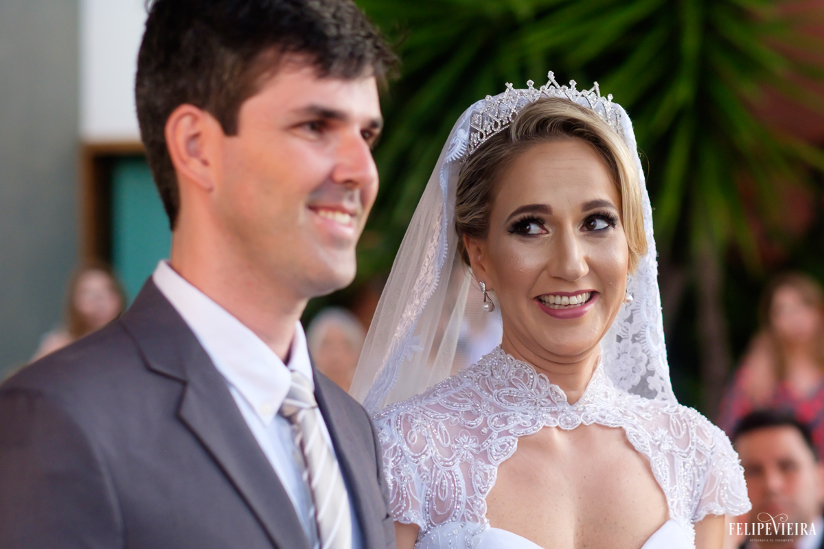 érica olhando para o seu amado durante a cerimonia com um belo sorriso foto do fotógrafo felipe vieira fotografia de casamento em Guarapari