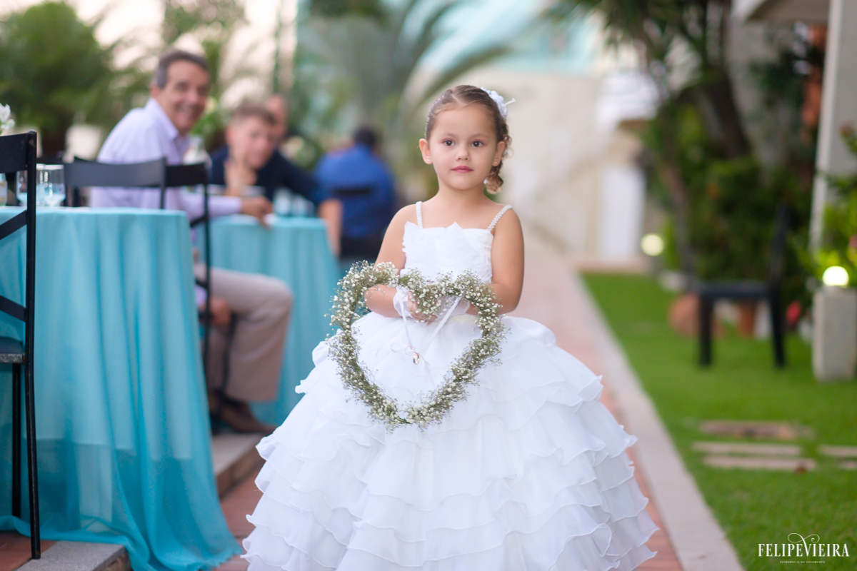 noivinha entrando com as alianças em um belo coração foto do fotógrafo felipe vieira fotografia de casamento em Guarapari