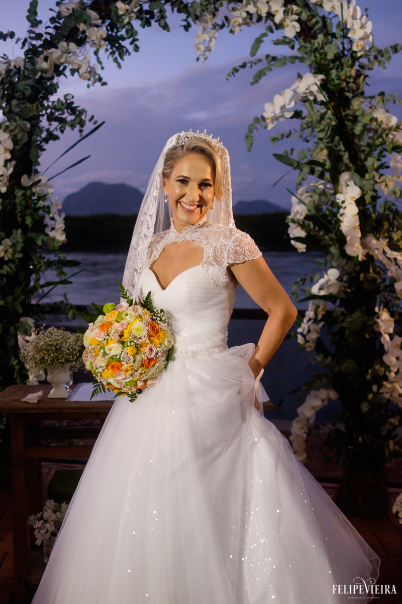 noiva feliz após se casar e posando em frente a bela paisagem foto do fotógrafo felipe vieira fotografia de casamento em Guarapari