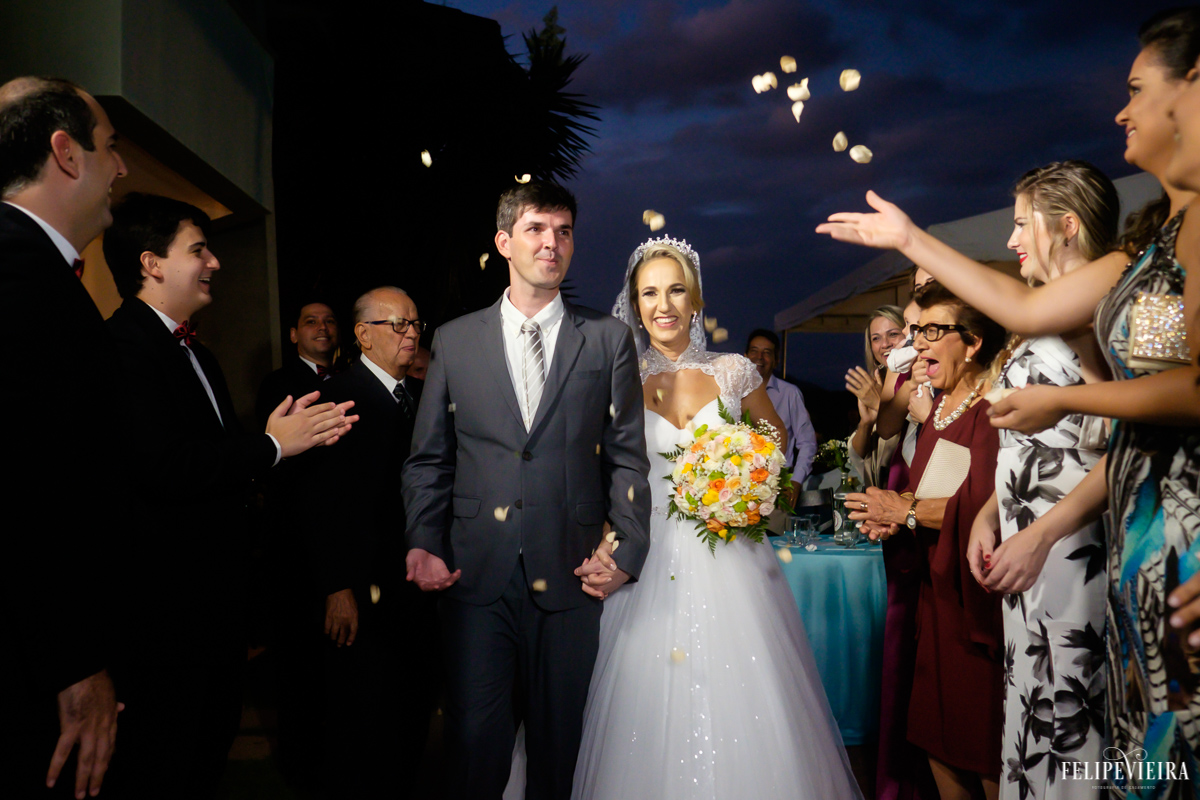 chegada dos noivos na recepção de forma divertida e alrgre foto do fotógrafo felipe vieira fotografia de casamento em Guarapari
