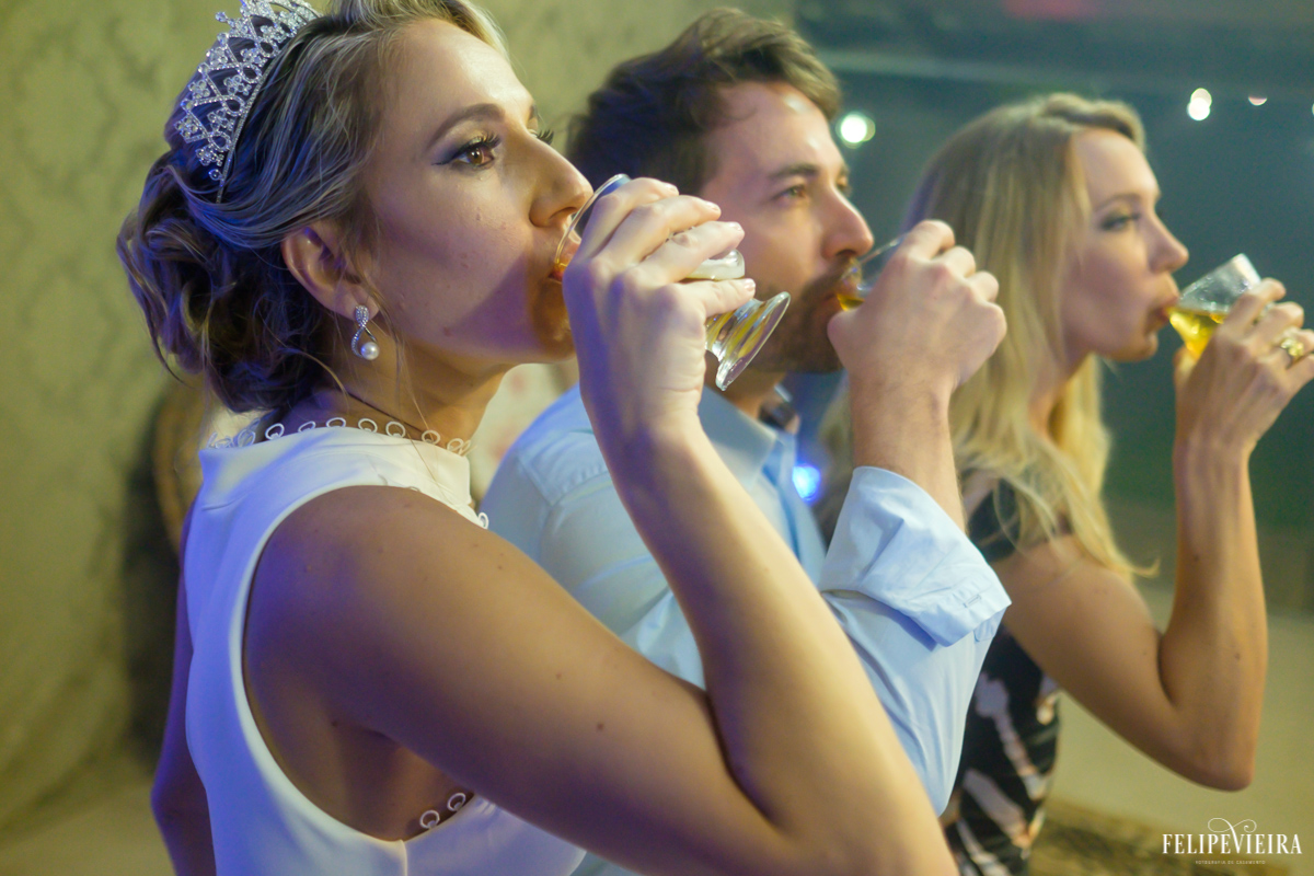 noiva bebendo na festa com os convidados em festa agitada foto do fotógrafo felipe vieira fotografia de casamento em Guarapari