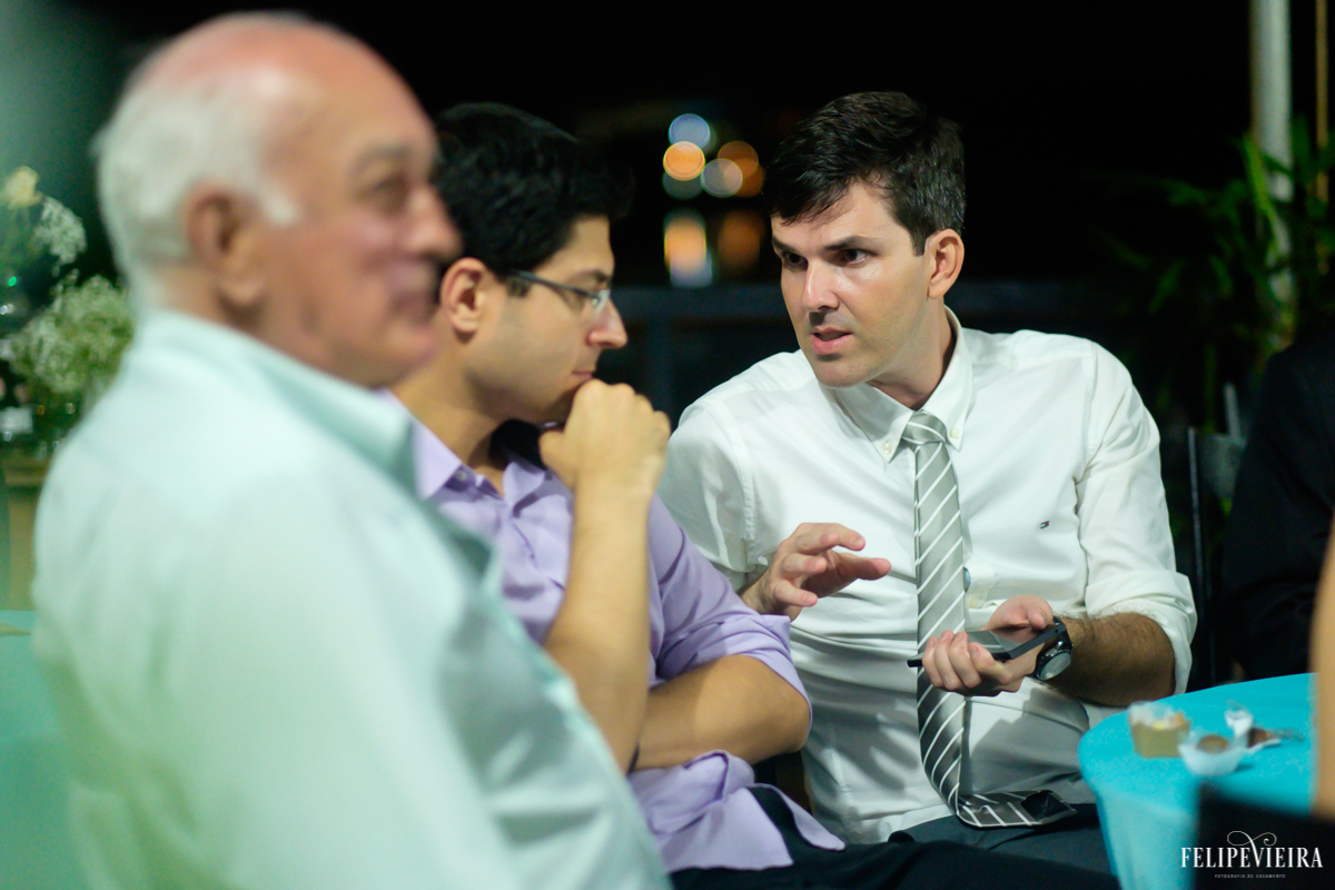 noivo imerso em uma boa conversa com convidados foto do fotógrafo felipe vieira fotografia de casamento em Guarapari