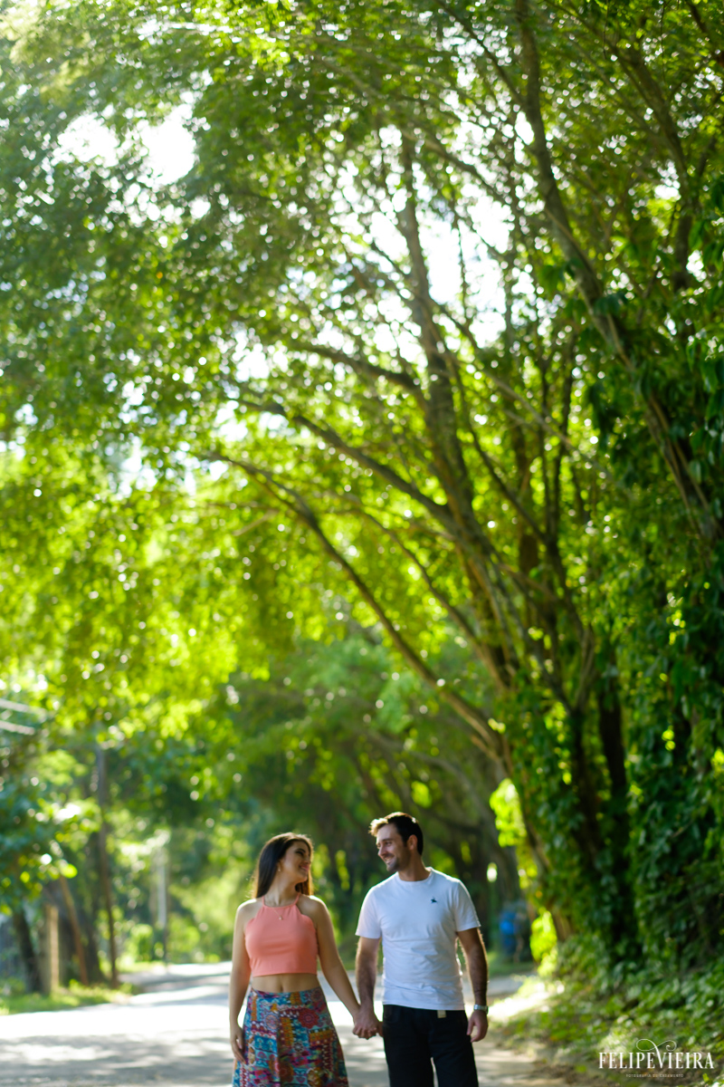 casal andando pelas árvores em ensaio externo Guarapari, foto feita por Felipe Vieira fotógrafo de casamentos.
