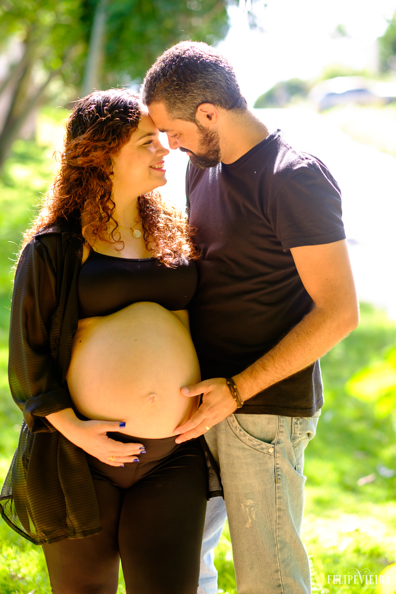 gestante com a cabeça apoiada na cabeça de seu marido felizes na área verde foto feita por felipe vieira fotógrafo de gestantes