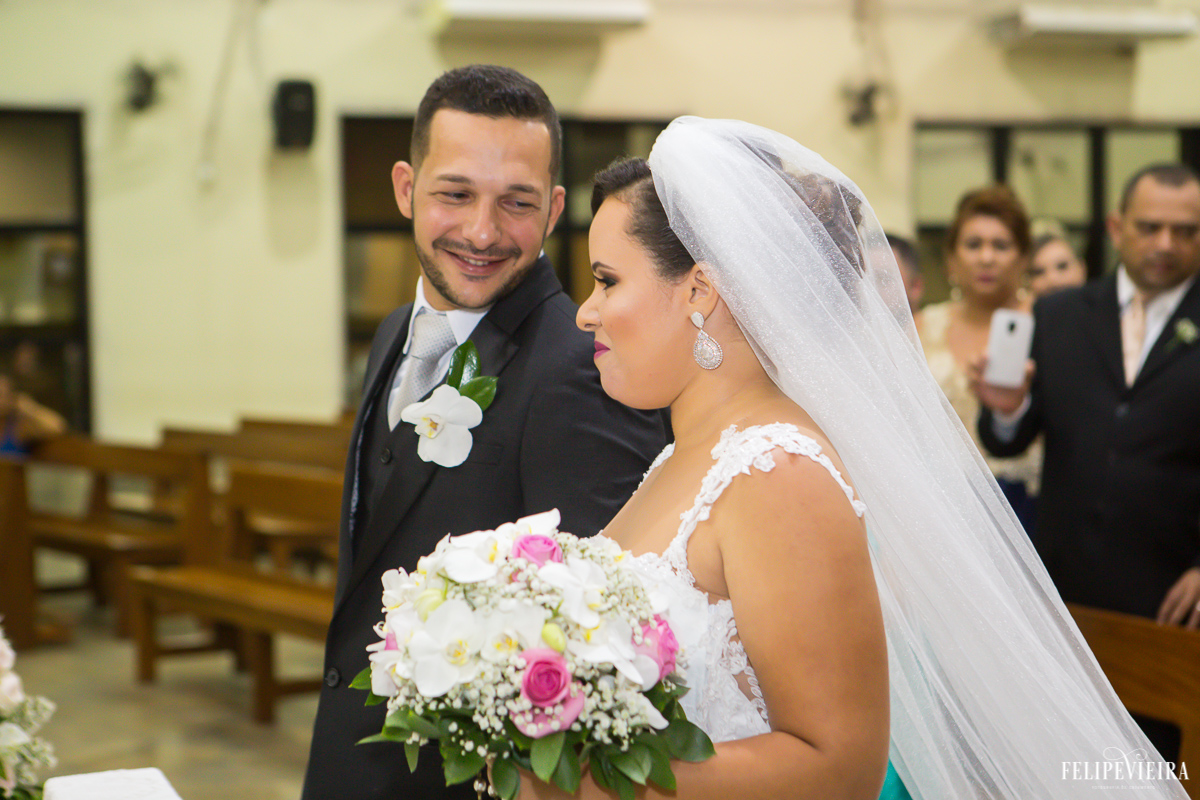 noivos no altar e Wagner olhando feliz para sua amada ao seu lado foto feita por Felipe Vieira fotógrafo de casamentos em Guarapari