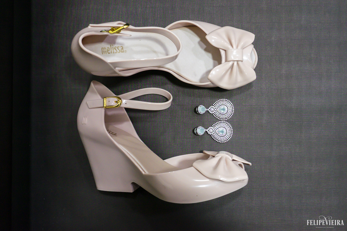 detalhes do sapato da noiva com um laço na ponta com seus brincos brancos no meio foto feita por Felipe Vieira fotógrafo de casamentos em Guarapari