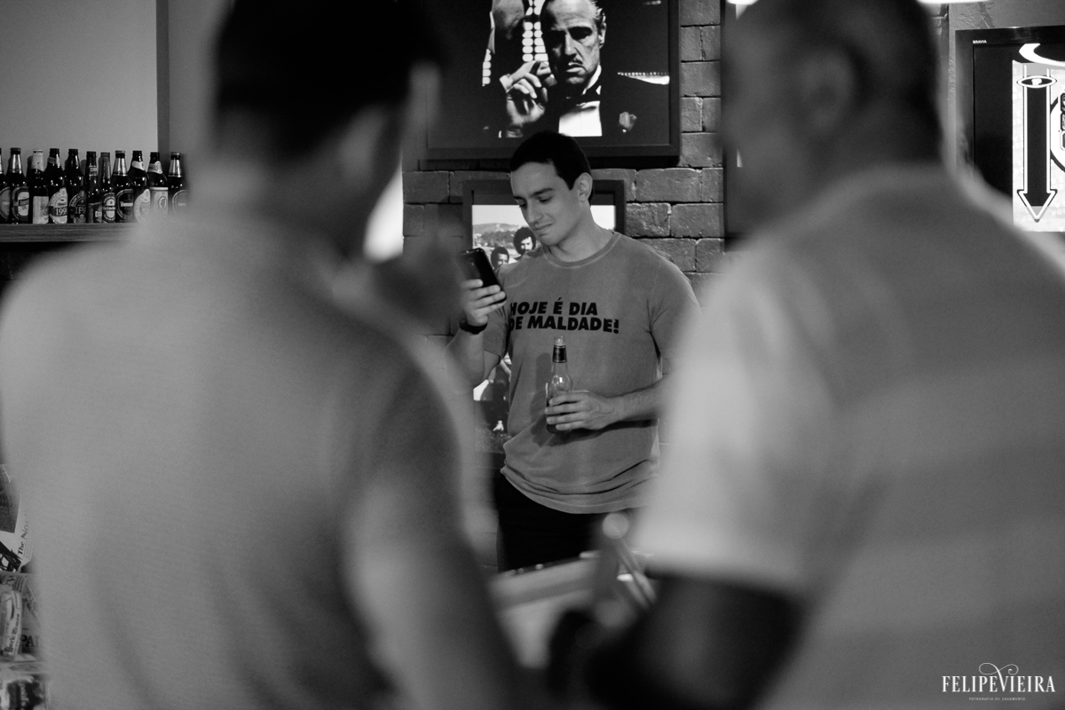 noivo Bruno relaxando antes do casamento mexendo em seu celular foto feita por Felipe Vieira fotógrafo de casamentos em Guarapari