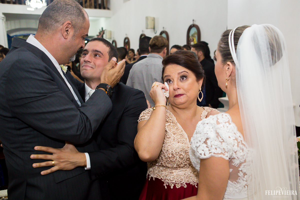 pais do noivo Bruno cumprimentando o casal com bastante emoção foto feita por Felipe Vieira fotógrafo de casamentos em Guarapari