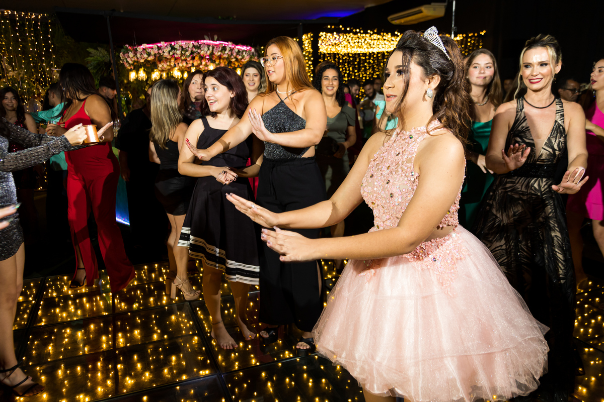 Gabriela dançando com alegria na pista de dança. Festa de 15 anos com fotografia em Guarapari capturando tudo.
