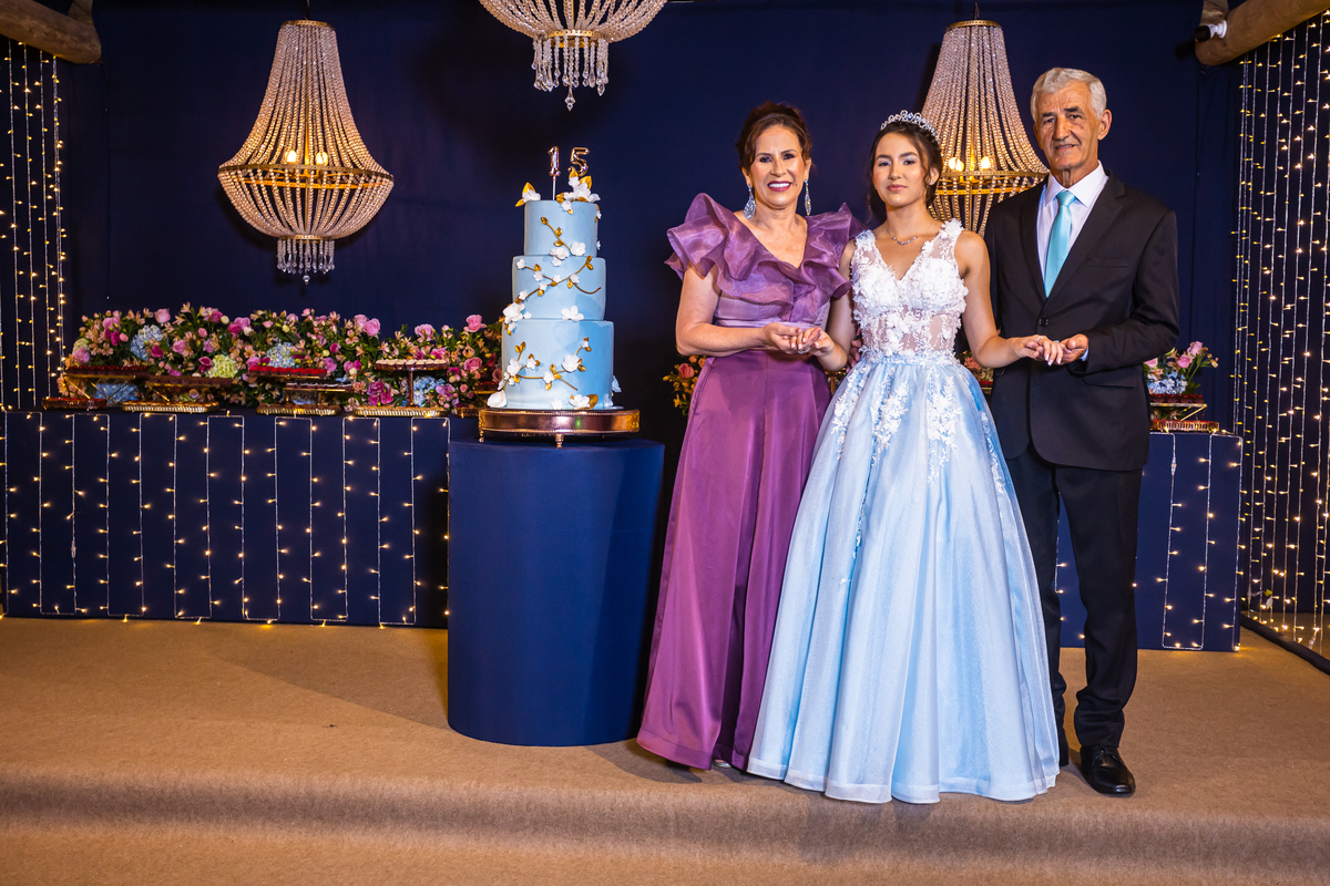 15 anos em Guarapari com vestido azul e muita naturalidade. Festa no cerimonial Country Eventos com pista de dança e bolo temático. Fotografias que capturam a essência da debutante.