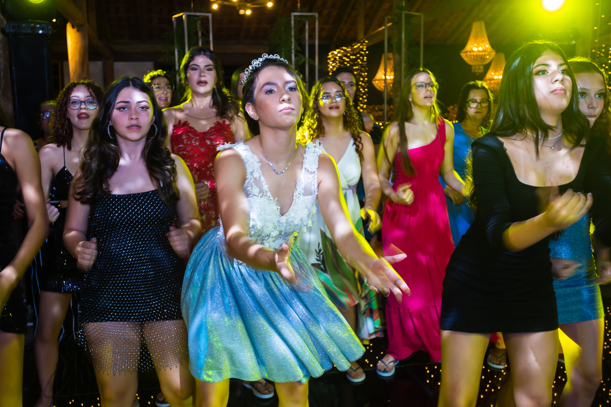 Vestido azul de debutante em um ensaio fotográfico em Guarapari. Festa no cerimonial Country Eventos com pista de dança animada. Bolo azul como grande destaque na celebração.