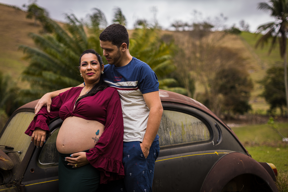 Ensaio gestante profissional num belo sítio com um carro enferrejudo sendo usado como pano de fundo para as fotos
