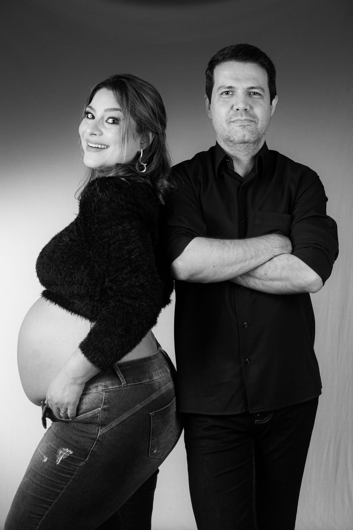 Ensaio de gestante em estúdio com iluminação suave. Fotografia de gestante com fundo neutro e luz natural.