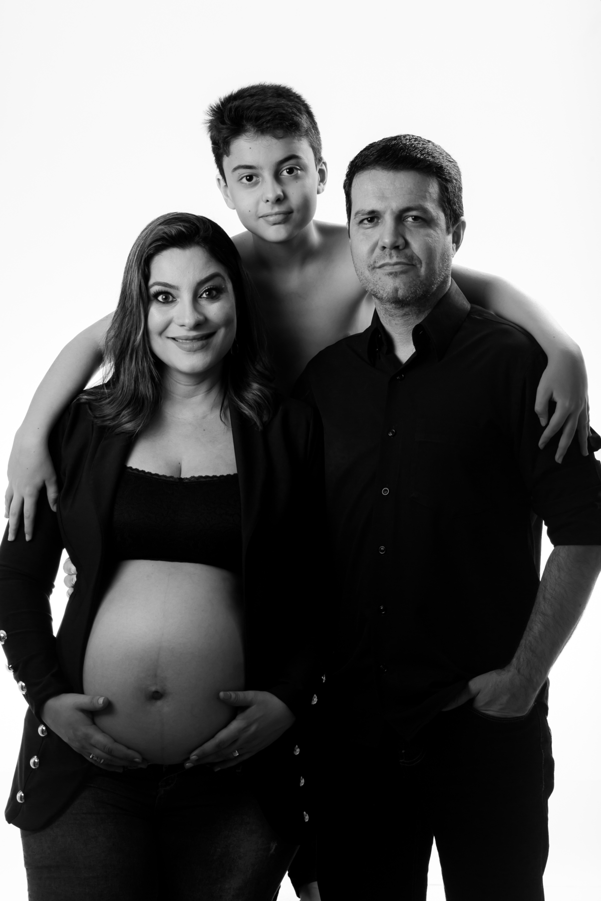 Sessão de fotos de gestante em estúdio com luz suave e foco no olhar. Ensaio de grávida com expressão natural e sorriso delicado.