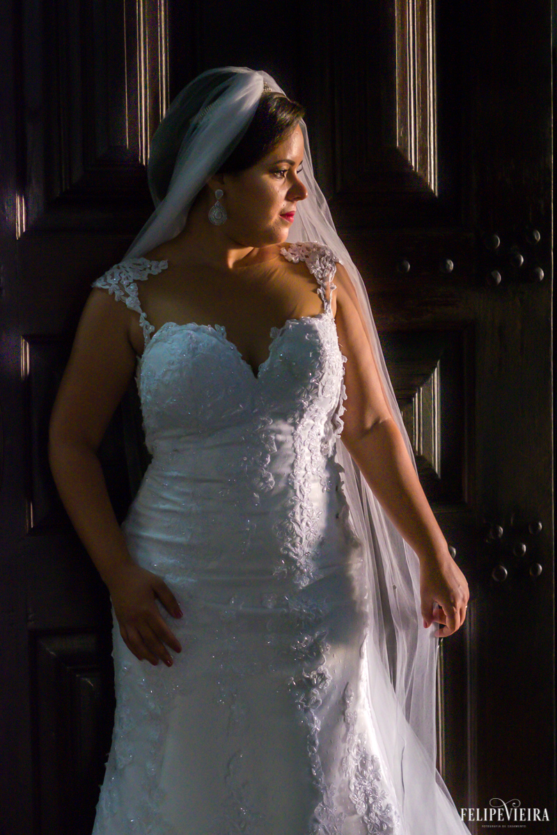 Detalhes de vestido de noiva com ela olhando sobre o ombro foto feita por felipe vieira fotógrafo de casamentos no convento da penha