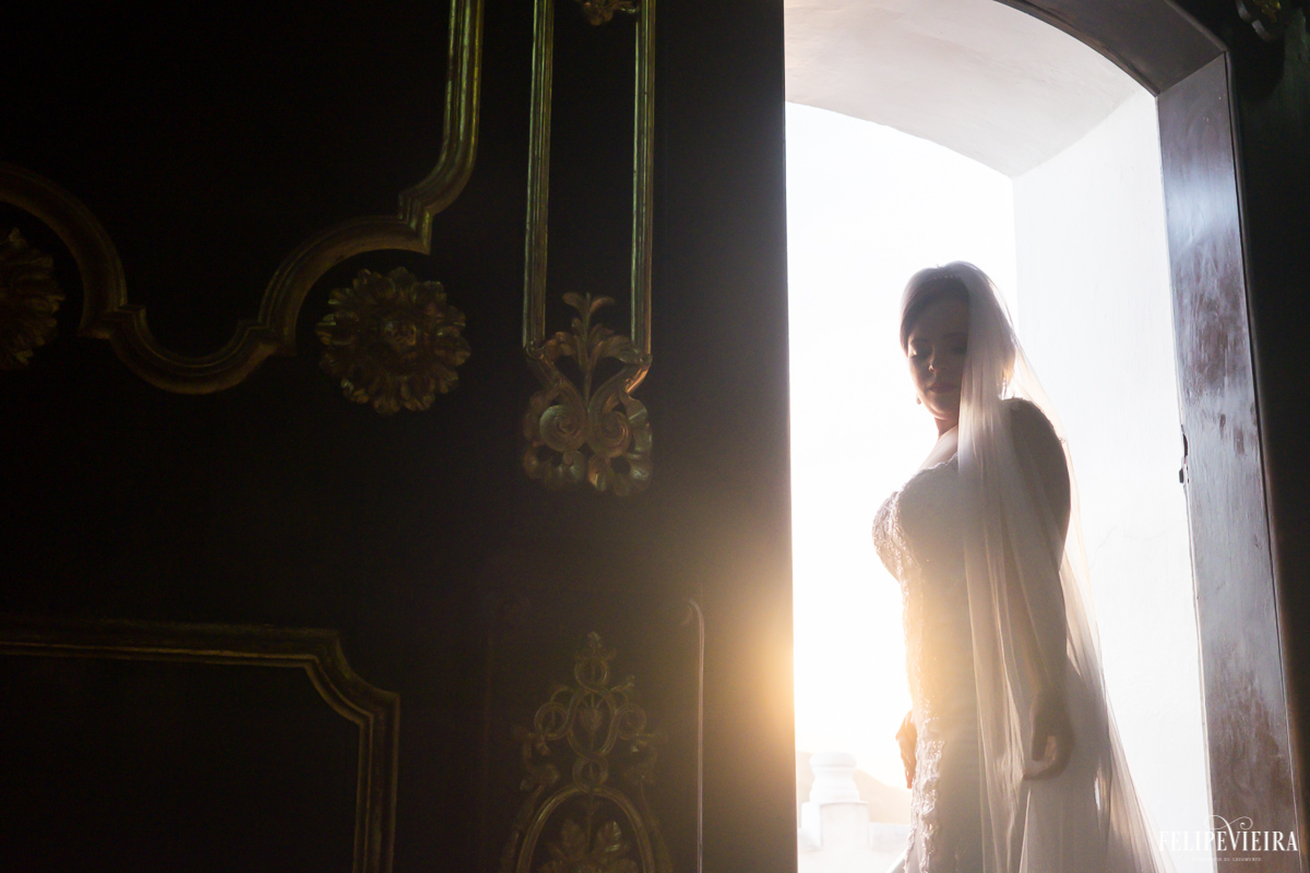 noiva mexendo em seu vestido na porta do convento da penha foto feita por felipe vieira fotógrafo de casamentos no convento da penha