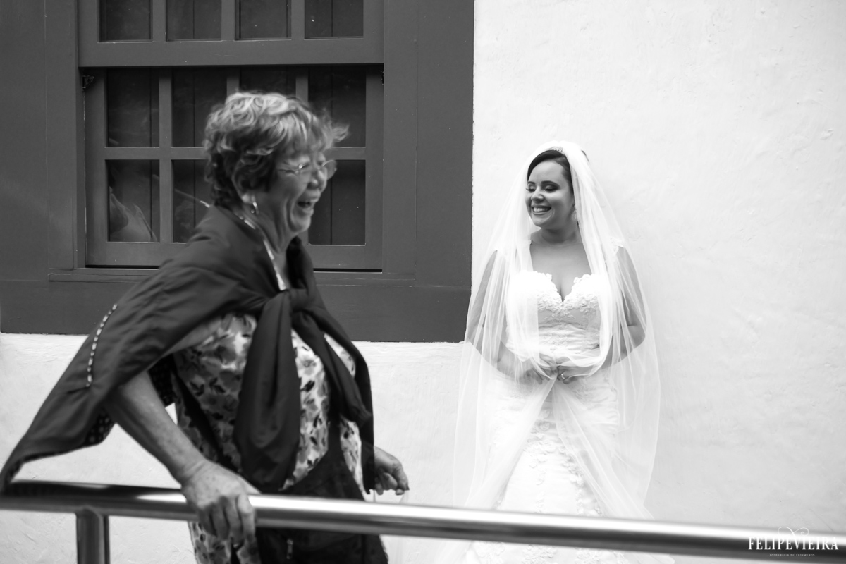 Senhora sorrindo enquanto noiva posa para foto em preto e branco foto feita por felipe vieira fotógrafo de casamentos no convento da penha