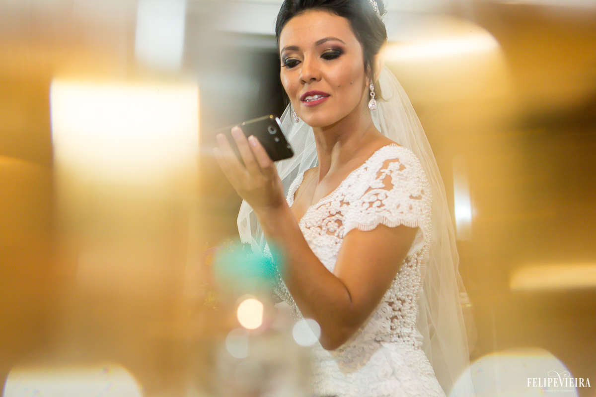 noiva olhando sua maquiagem no celular antes do casamento em foto feita por felipe vieira fotografo de casamentos em guarapari