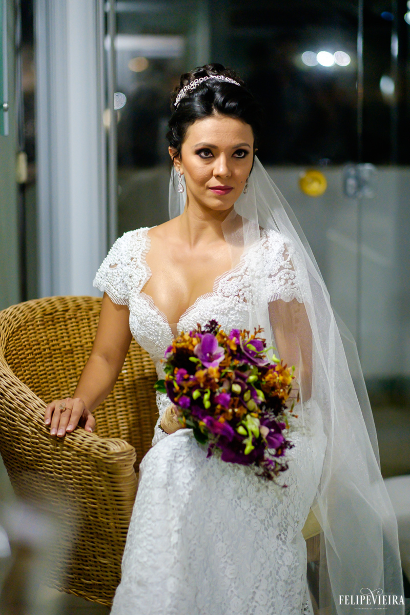 noiva posando para foto com seu buquê roxo e detalhe do decote do vestido em foto feita por felipe vieira fotografo de casamentos em guarapari