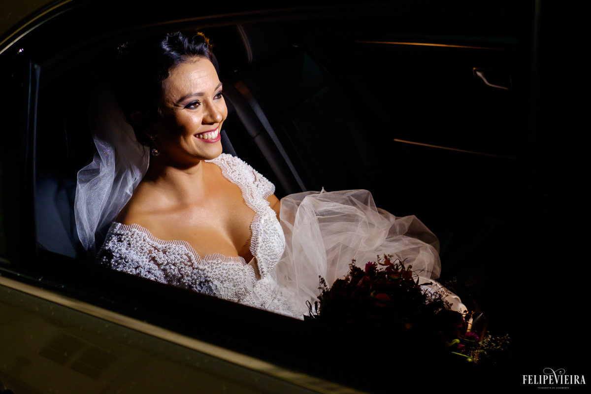 noiva no carro em frente a igrejinha velha em guarapari prestes a sair para a cerimônia em foto feita por felipe vieira fotografo de casamentos em guarapari