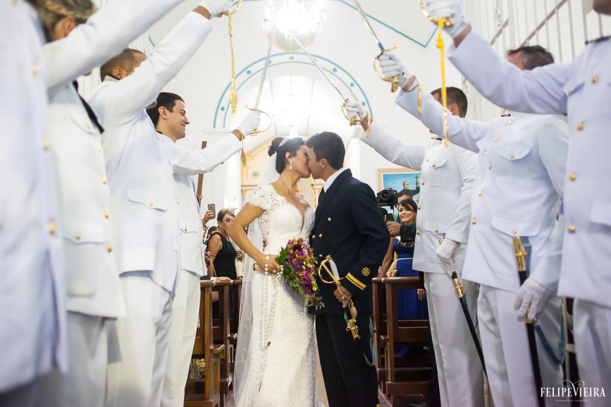 Noivos se beijando em frente da frota militar de espadas erguidas em foto feita por felipe vieira fotografo de casamentos em guarapari