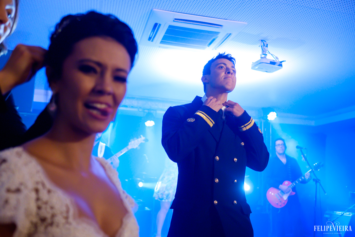 noivo ajeitando a gravata enquanto a noiva faz uma cara divertida em foto feita por felipe vieira fotografo de casamentos em guarapari