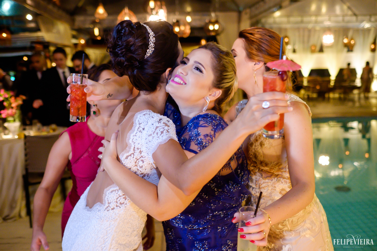 Noiva cumprimentando suas amigas na festa com as bebidas em mãos em foto feita por felipe vieira fotografo de casamentos em guarapari