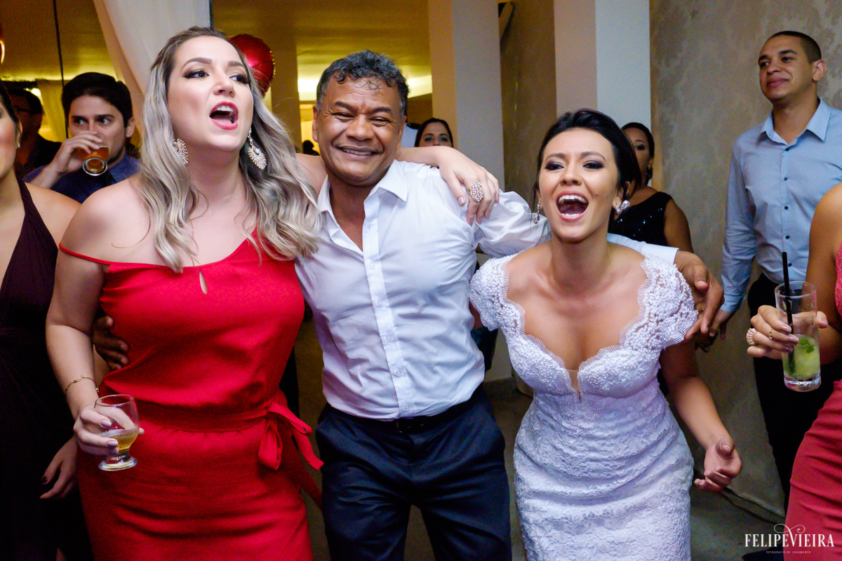 pai da noiva com madrinha e com a noiva rindo e dançando em foto feita por felipe vieira fotografo de casamentos em guarapari