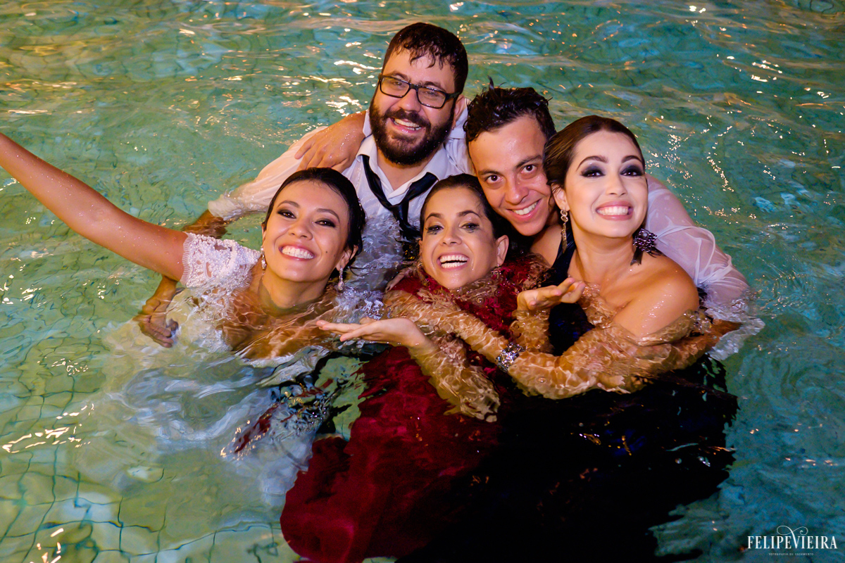 noivos e amigos dentro da piscina no final da festa em foto feita por felipe vieira fotografo de casamentos em guarapari