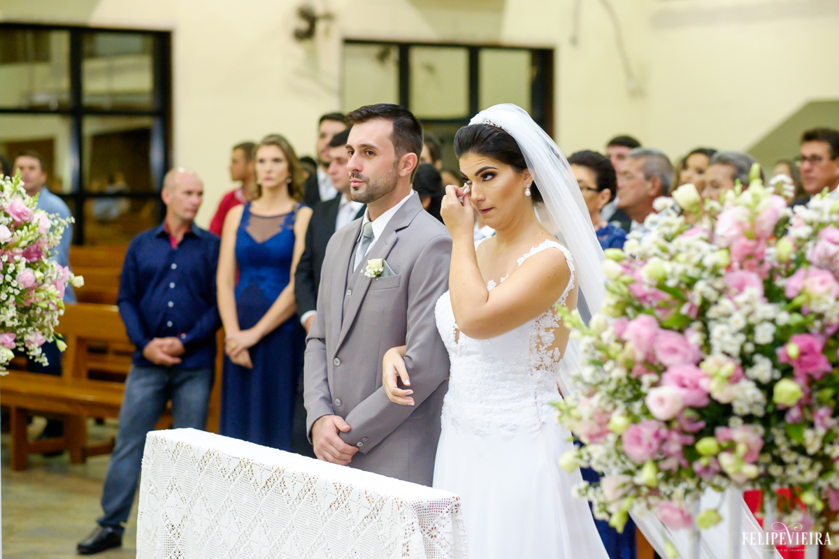 Noiva enxugando lágrimas de seus olhos no altar com seu noivo foto feita por felipe vieira fotografo de casamentos em guarapari