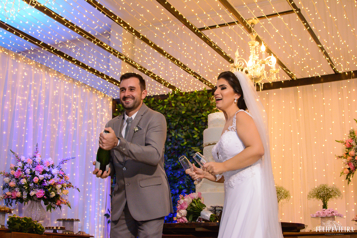 Noivo estourando champanhe para servi-lo a noiva na festa foto feita por felipe vieira fotografo de casamentos em guarapari