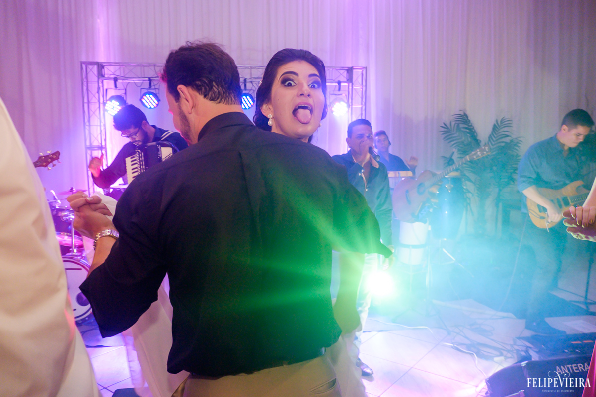 Noiva fazendo cara divertida ao dançar com convidado foto feita por felipe vieira fotografo de casamentos em guarapari