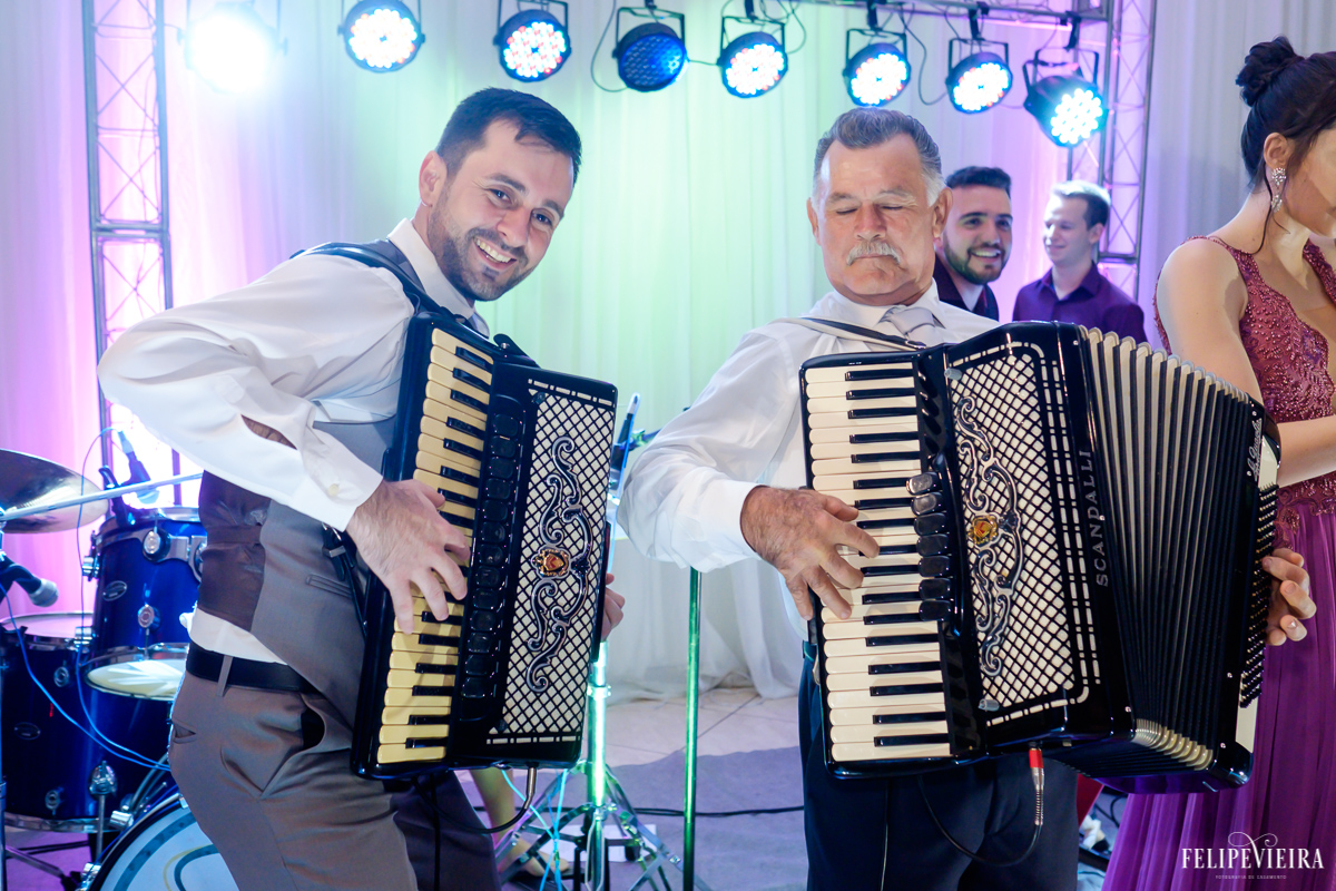 Noivo tocando sanfona junto com a banda e agitando a festa foto feita por felipe vieira fotografo de casamentos em guarapari