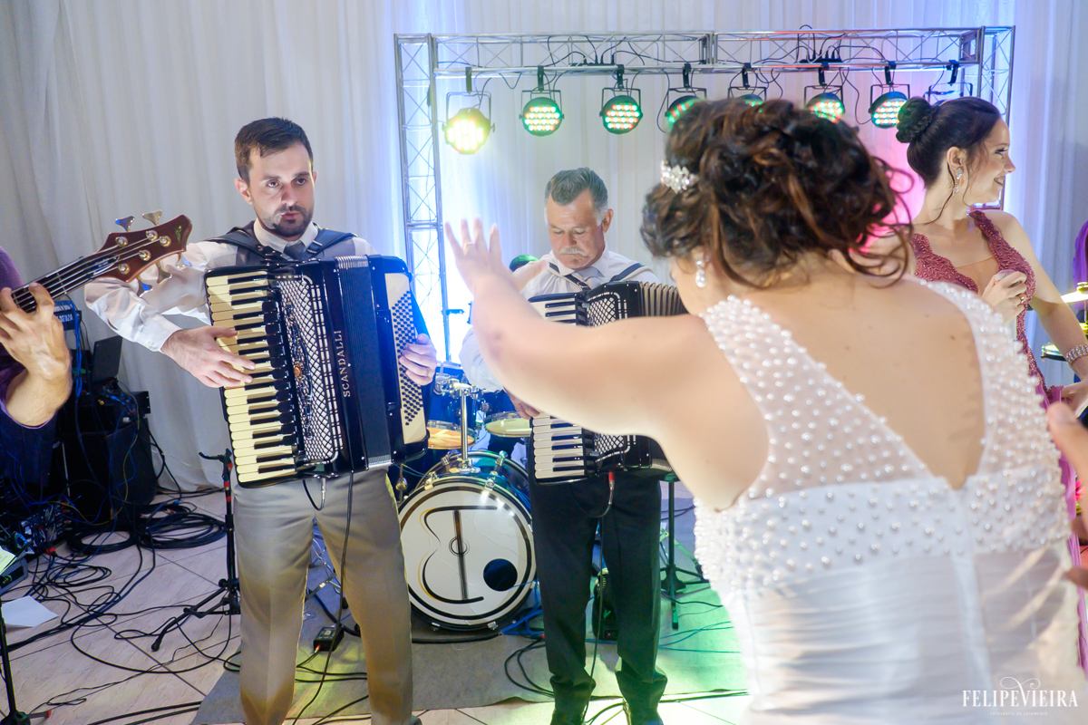 Noiva vendo seu esposo tocando sanfona e dançando foto feita por felipe vieira fotografo de casamentos em guarapari
