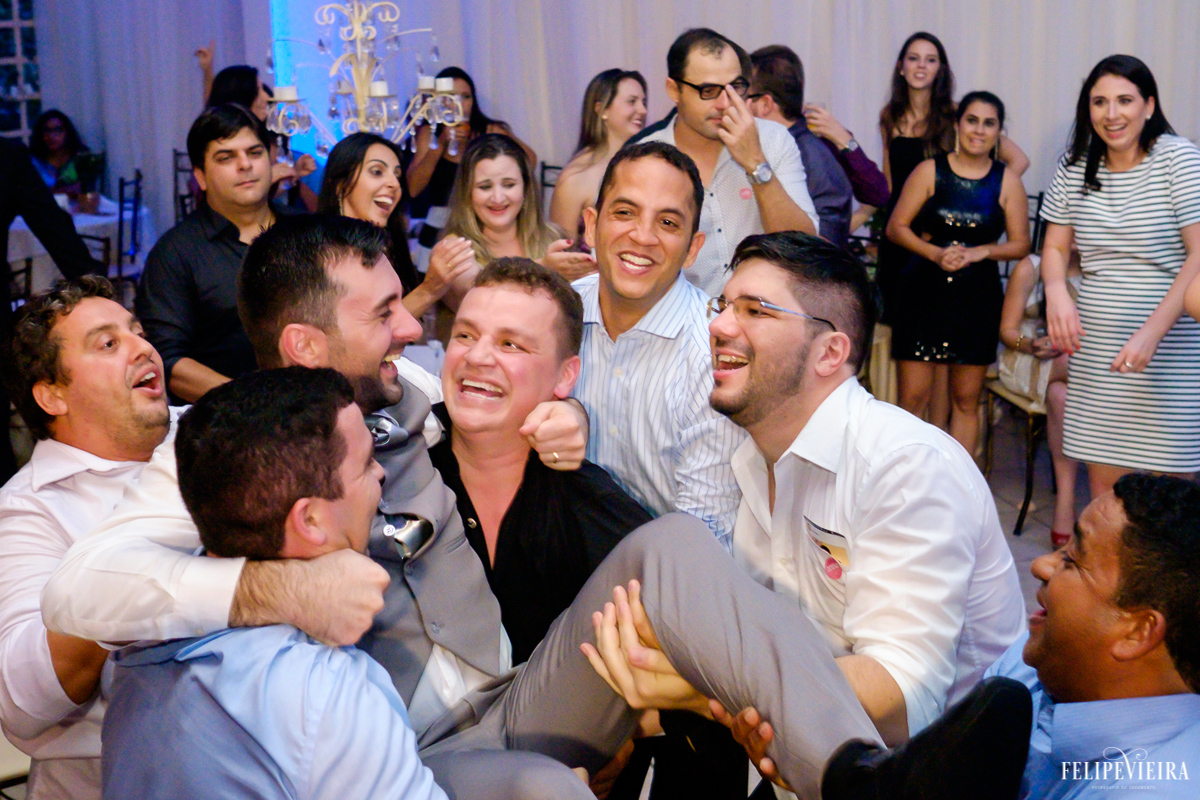 Noivo sendo jogado para cima pelos padrinhos divertidos foto feita por felipe vieira fotografo de casamentos em guarapari