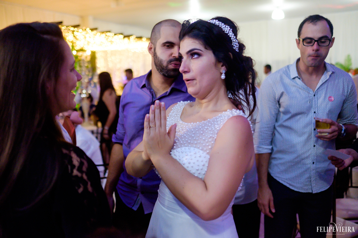 Noiva com expressão divertida no rosto enquanto conversa com convidados no fim da festa foto feita por felipe vieira fotografo de casamentos em guarapari