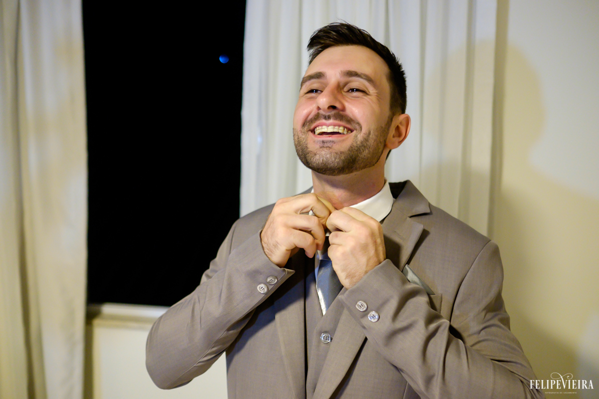 noivo arrumando a gravata antes do casamento foto feita por felipe vieira fotografo de casamentos em guarapari