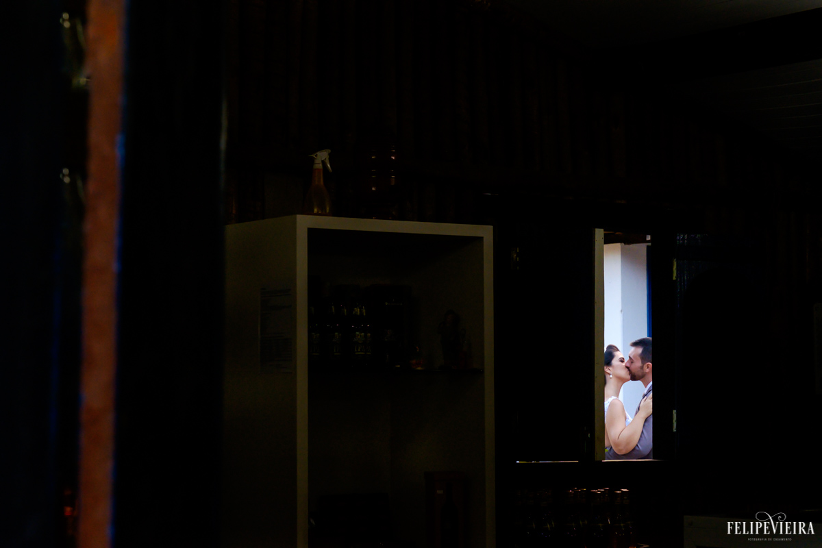 detalhe de noivos se beijando ao fundo da imagem foto feita por felipe vieira fotografo de casamentos em guarapari