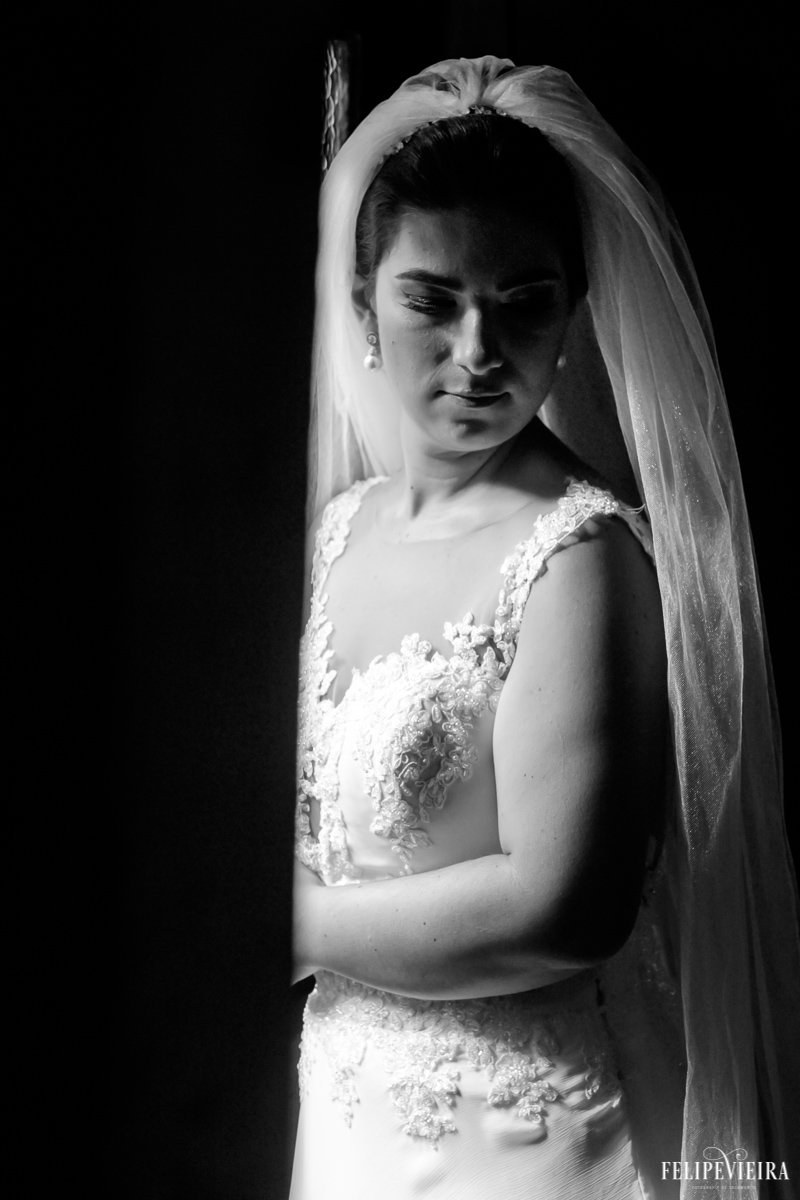 foto em preto e branco de detalhes do vestido da noiva e do véu por trás de seu ombro foto feita por felipe vieira fotografo de casamentos em guarapari