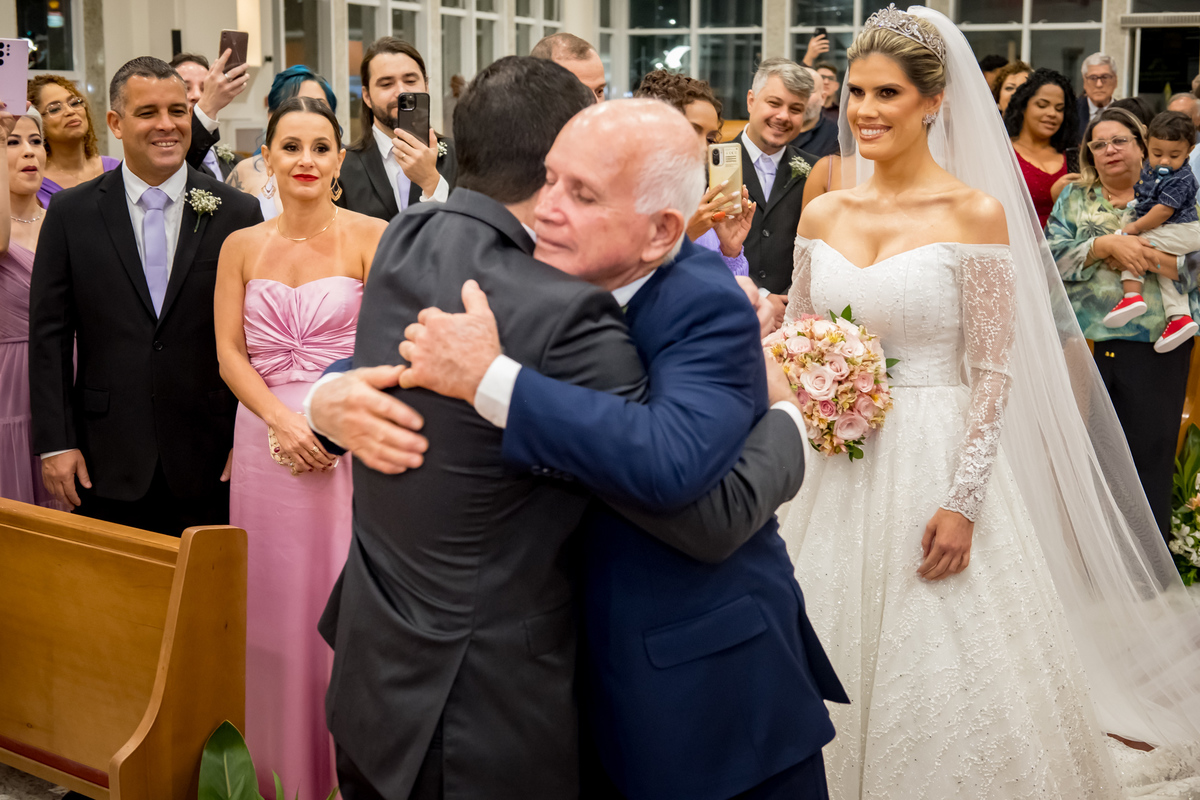 Noivo abraçando o pai da noiva no momento de entrega da noiva 