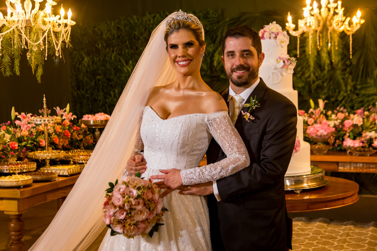 A mesa do bolo se torna o cenário perfeito para retratos dos noivos, com fotografia de casamento no Espírito Santo destacando a beleza do momento.