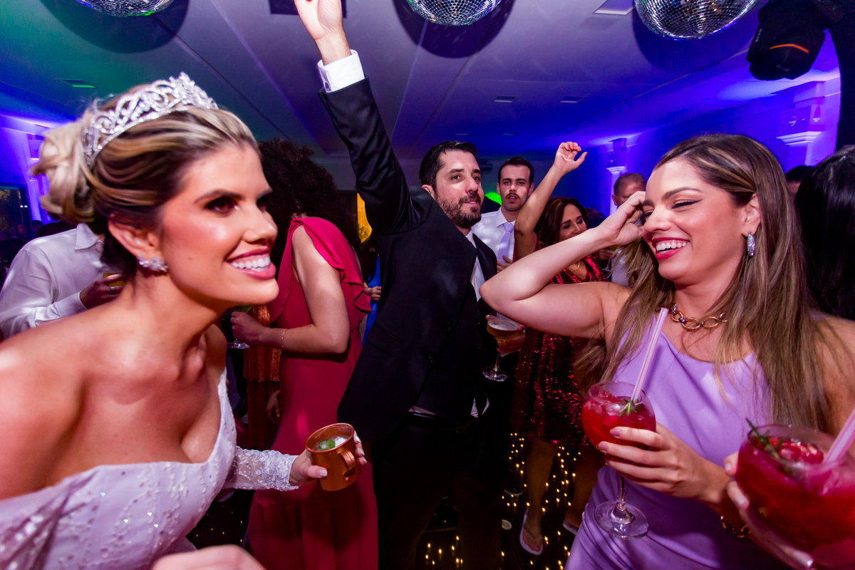 Noivos e convidados vibrando juntos ao som de clássicos na pista de dança.