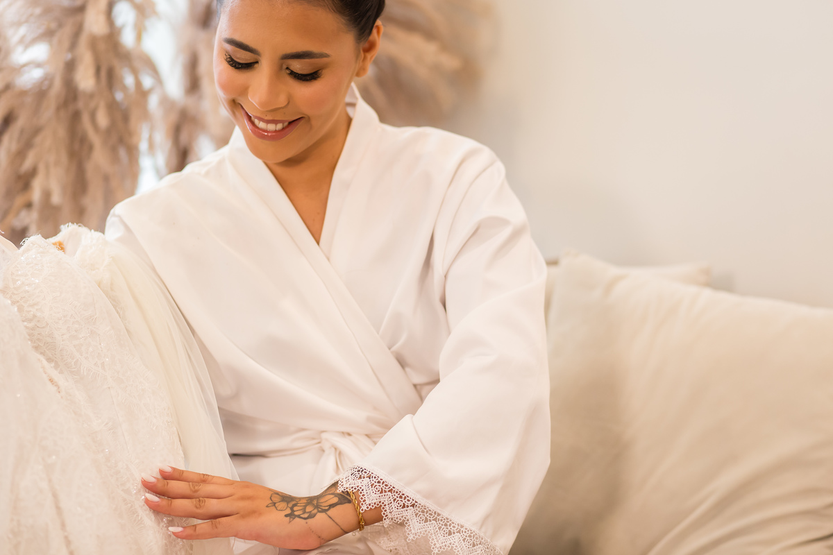 Capturando a emoção no making of da noiva: cada detalhe do vestido sendo ajustado.
Maquiagem de noiva impecável realçando a beleza natural no dia especial.