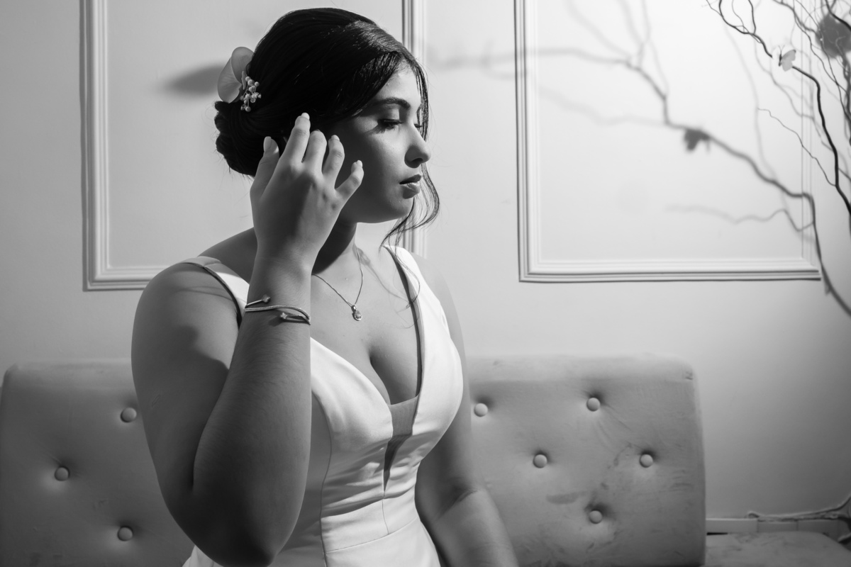 Penteado da noiva elaborado com elegância para complementar o véu clássico.