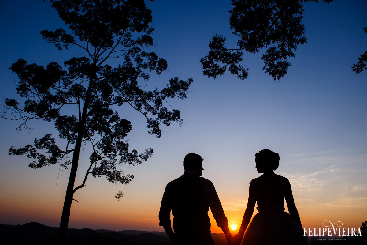 silhueta de noivos com o sol entre suas mãos se pondo foto felipe vieira fotografo de casamentos guarapari