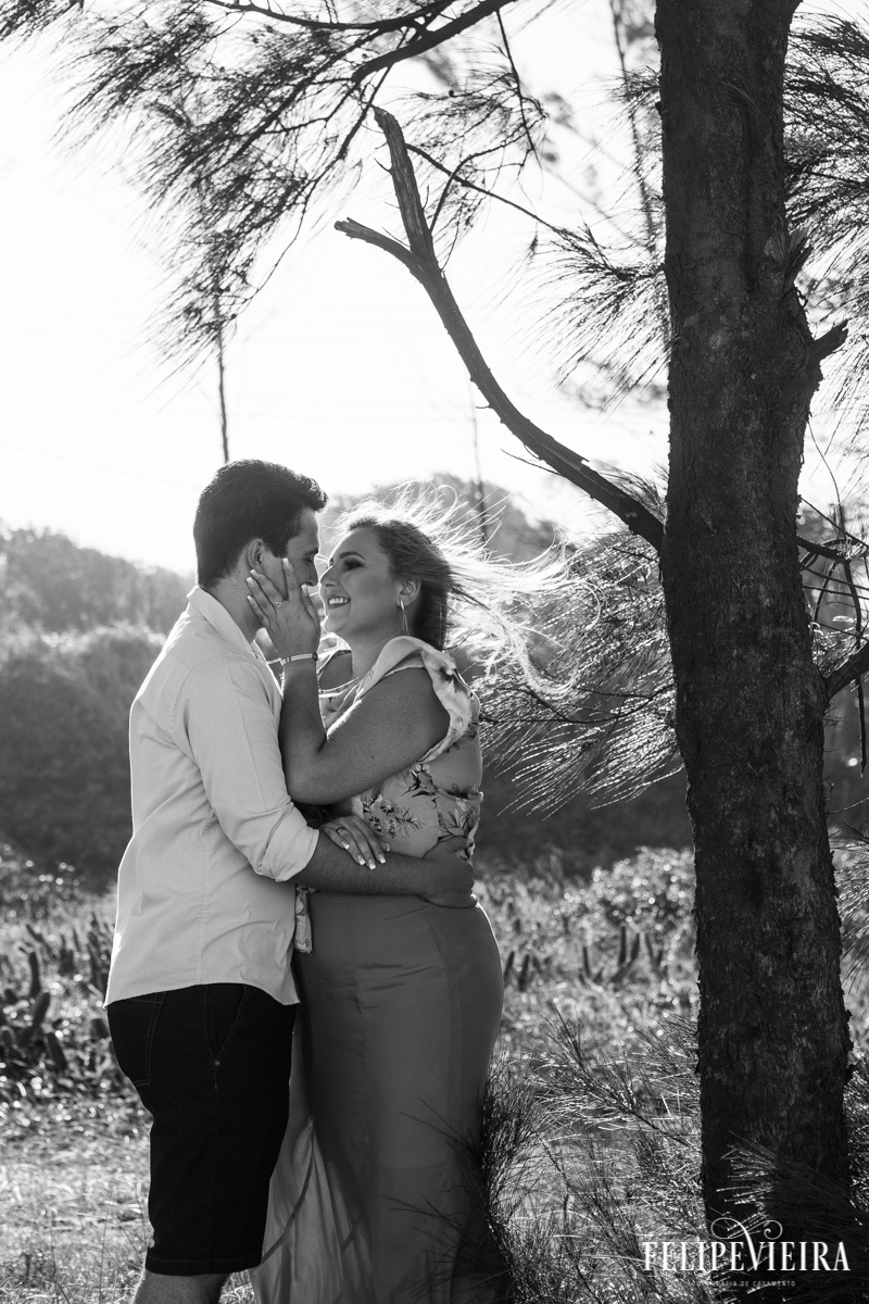 Ensaio de casal na praia em Guarapari em preto e branco com a noiva sorrindo para o noivo pelo fotografo de casamento em Guarapari Felipe Vieira Fotografia de casamento